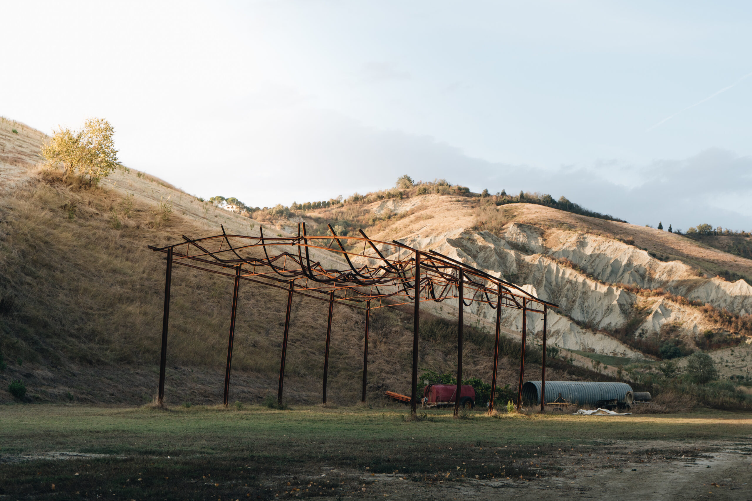 A broader view of the structure, showcasing its worn metal framework against a backdrop of layered hills and clear skies
