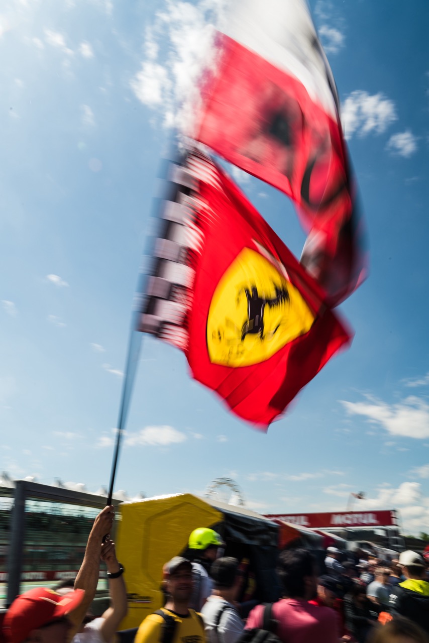 Ferrari flag waves high above fans at the Imola Circuit during a race