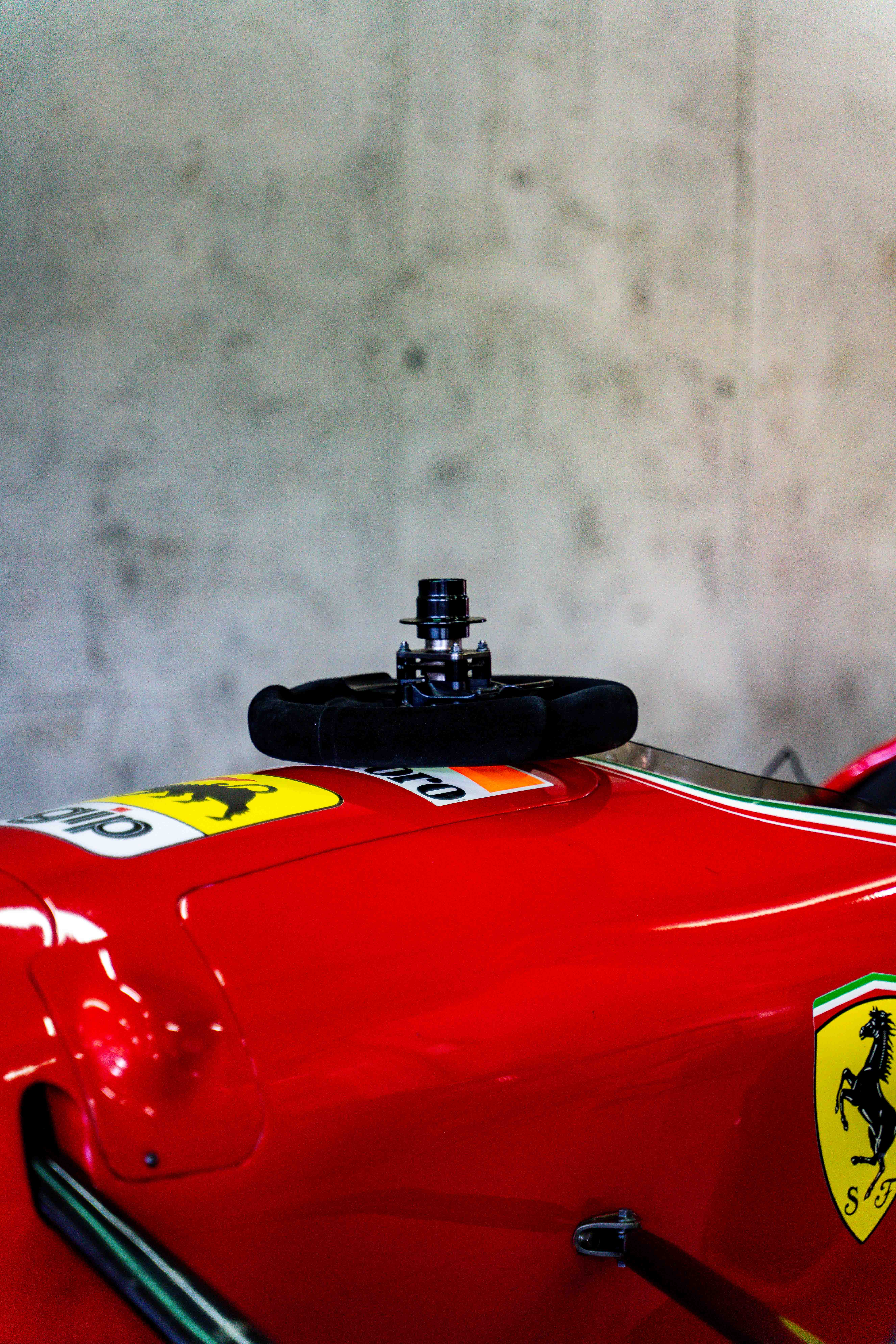 Close-up of a classic red Ferrari Formula 1 car showcasing its exposed steering wheel