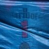 _CLC4446 Close-up of a blue racing cover featuring a faded “number 1” symbol with logos underneath, draped over a structure