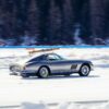 Silver vintage Ferrari with wooden skis on the roof rack, driving on ice at The I.C.E. St. Moritz 2023