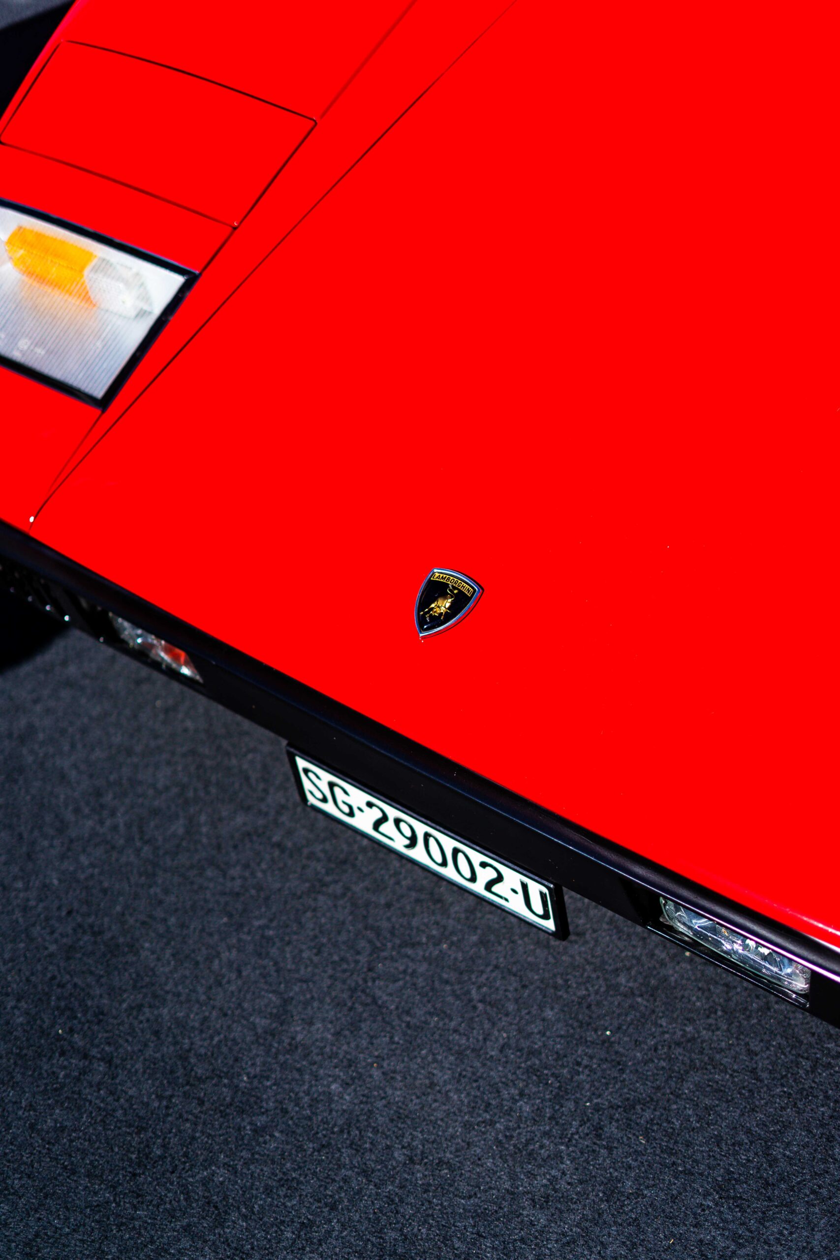 Front hood of a red Lamborghini with emblem, captured under natural light at The I.C.E. St. Moritz 2023