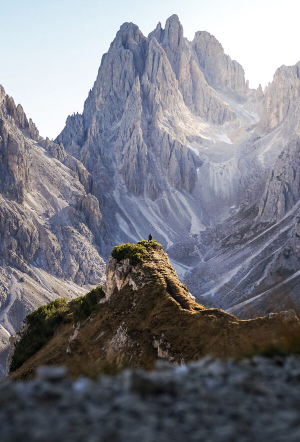 Rugged mountain peaks illuminated by soft sunlight with a rocky foreground.
