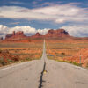 Iconic road leading to Monument Valley's sandstone buttes under dramatic summer clouds, Utah