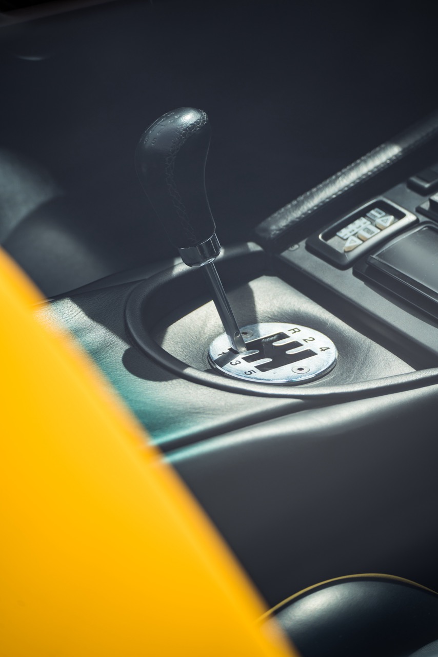 Interior shot of a Lamborghini, featuring a classic gated manual shifter and luxurious detailing