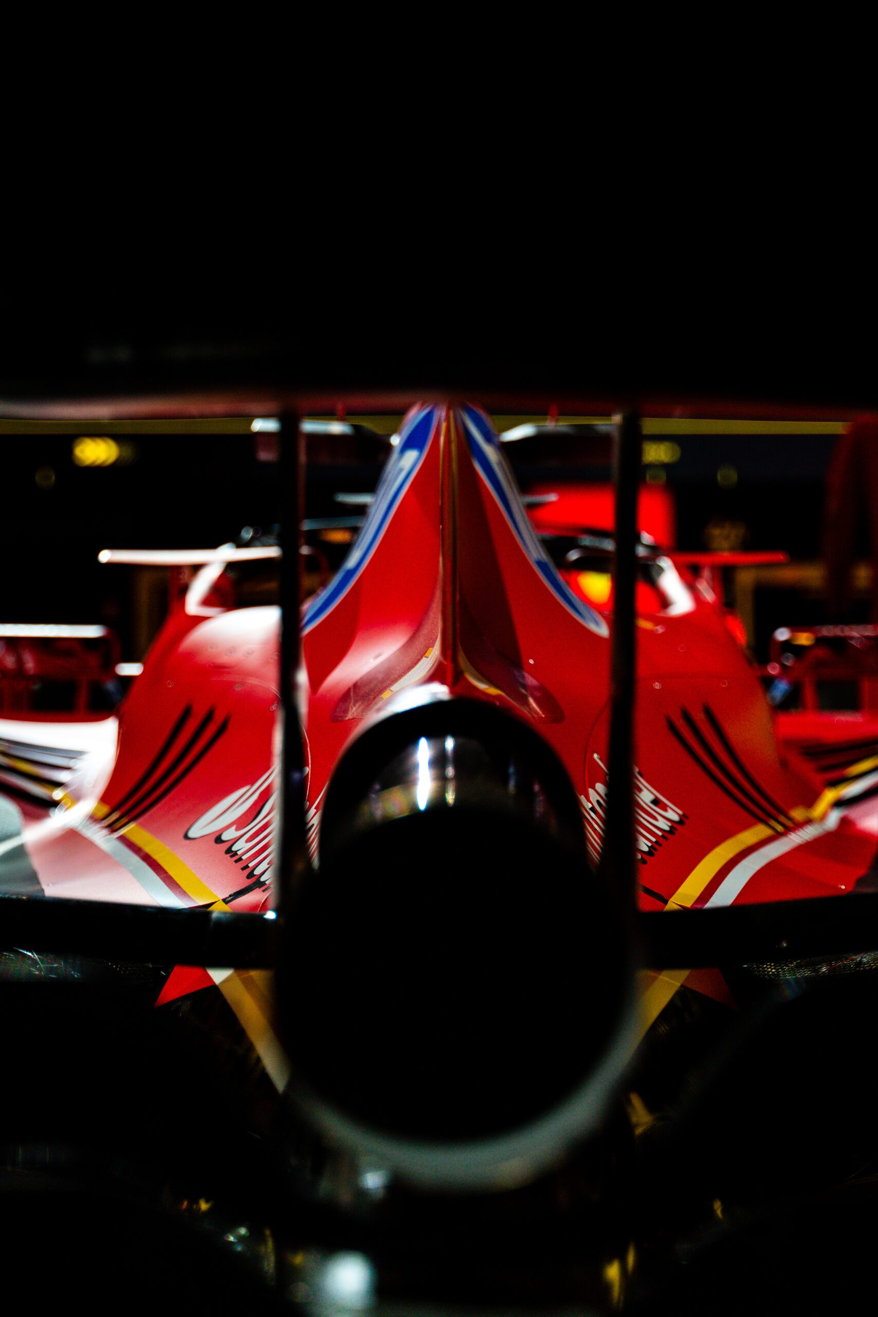 Rear view of a Ferrari Formula 1 car focusing on the aerodynamic design and exhaust system under dramatic lighting